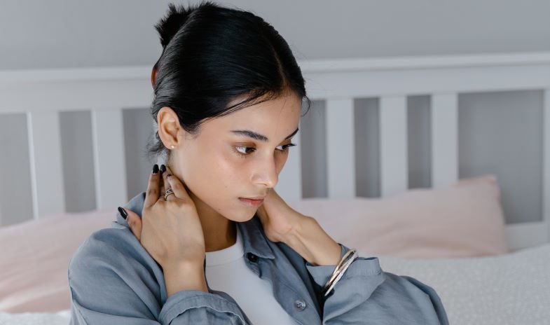 ragazza che si spalma un olio per la cervicale