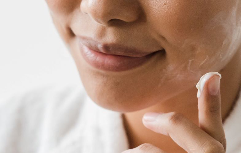 donna che usa la crema per il viso alla canapa